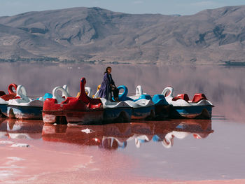 Boats in lake against mountains