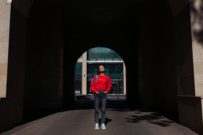 Portrait of woman standing against brick wall