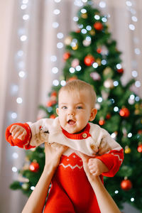 Portrait of cute girl holding christmas tree