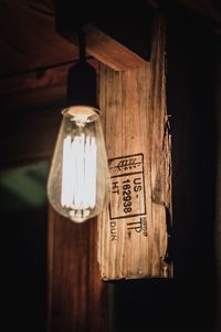 Close-up of illuminated light bulb hanging on table