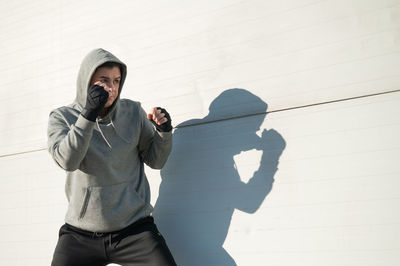 Low angle view of woman standing against wall