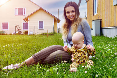 Portrait of smiling young woman sitting on field
