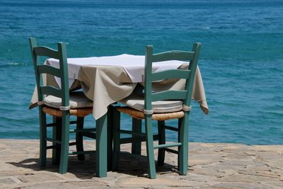 Empty chairs and lounge chair at beach