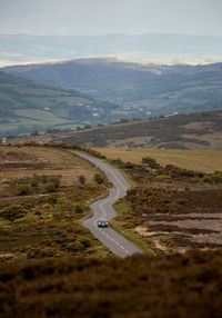 Aerial view of road amidst field against sky