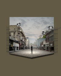 Rear view of man walking on street against buildings in city