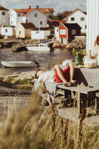 Woman sitting outside house against buildings