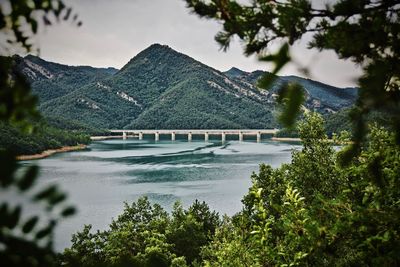 Scenic view of river by dam against sky