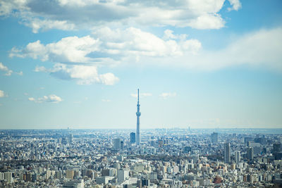 Aerial view of buildings in city against cloudy sky