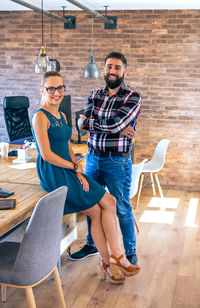 Portrait of young couple sitting on wooden floor