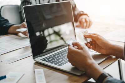 Midsection of man using laptop on table