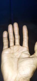 Close-up of human hand against black background