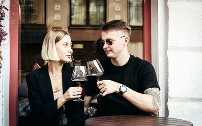 Young couple sitting in a drinking glass