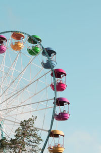 Low angle view of ferris wheel against clear blue sky