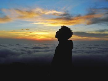 Silhouette woman standing against sky during sunset