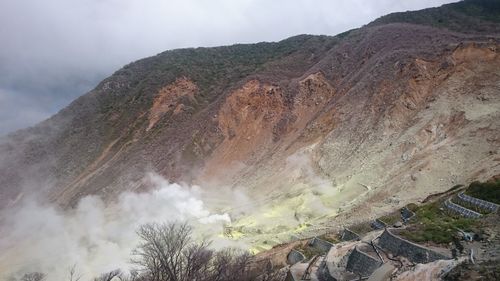 Smoke emitting from volcanic mountain against sky