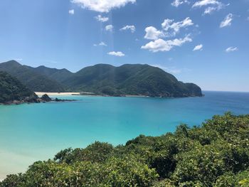 Scenic view of sea and mountains against sky