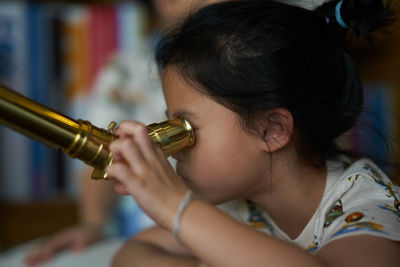 Close-up of girl looking through binoculars