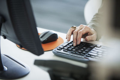 Midsection of man using laptop on table