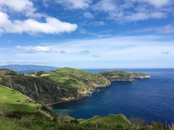 Scenic view of sea and mountains against sky