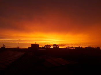 Silhouette buildings against sky during sunset