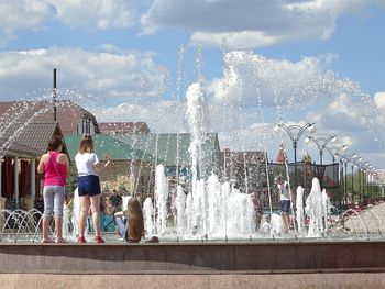 People at fountain in city