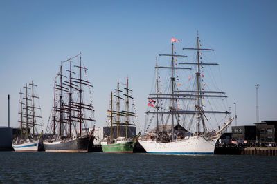 Sailboats in sea against clear sky