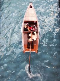 High angle view of people sitting on boat at lake