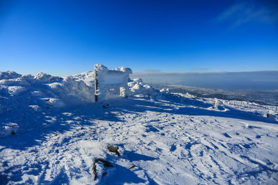 Scenic view of snowcapped mountain against blue sky