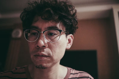 Portrait of young man wearing eyeglasses at home