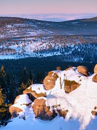 Rocky peak above inverse mist. winter weather in mountains, colorful fog. misty valley in winter