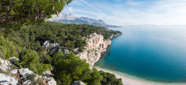 Scenic view of sea and mountains against sky