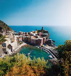 High angle view of townscape by sea against clear sky