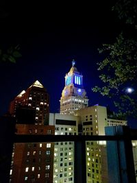 Low angle view of illuminated buildings against sky at night