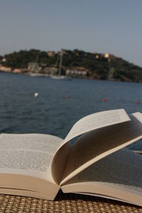 Close-up of open book at seaside