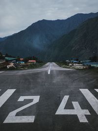 Road sign on mountain against sky