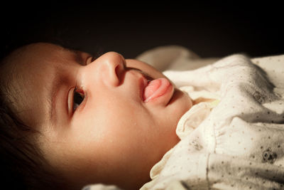 Close-up portrait of baby lying down on bed