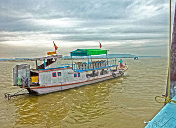 Boat moored on sea against sky