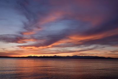 Scenic view of sea against dramatic sky during sunset