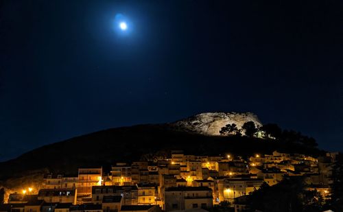 Illuminated buildings in city against sky at night