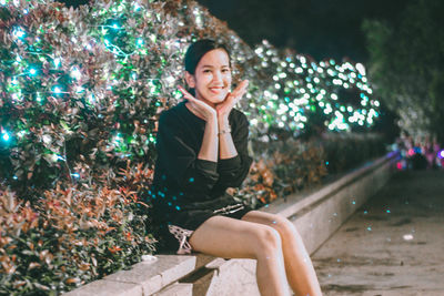 Portrait of smiling young woman sitting outdoors
