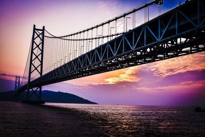 Low angle view of akashi kaikyo bridge over strait against sky during sunset