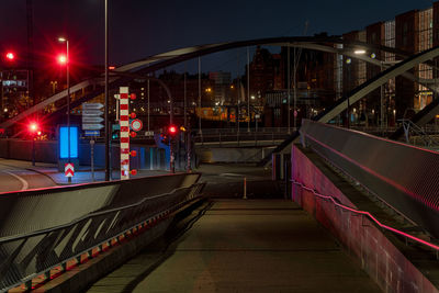 Illuminated bridge amidst buildings in city at night