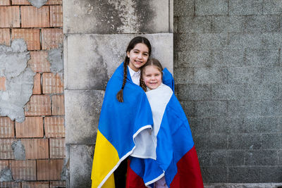 Portrait of smiling girls wrapped in blanket