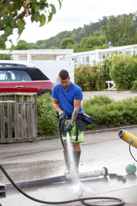 Man using hose pipe on building site