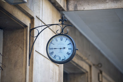 Low angle view of clock on wall in building