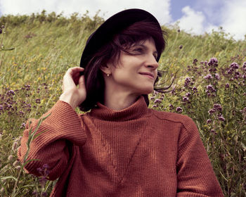 Portrait of brunette smiling looking away young adult woman from below  in wildflower field karelia