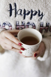 Midsection of woman holding coffee cup