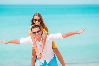 Portrait of smiling woman with sunglasses against sea