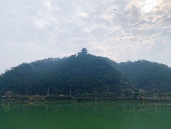 Scenic view of lake by mountains against sky