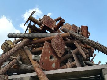 Low angle view of rusty metal against sky